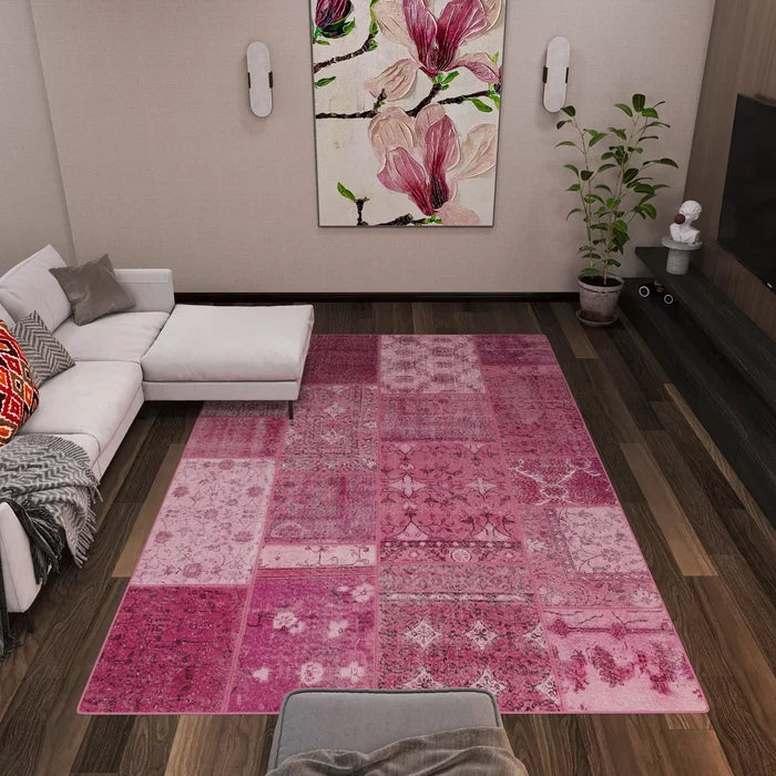 Modern living room with a white sectional sofa, gray blanket, red pillow, potted plant, floral wall art, TV on a dark wood entertainment unit, and the Berry Patchwork - Washable Rug - JRN1040 perfect for high-traffic areas.