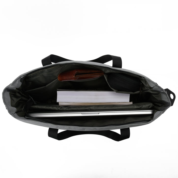 Open top view of a black tote bag with laptop, notebook, and accessories neatly organized inside.