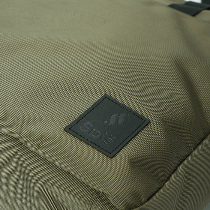 Close-up olive green backpack with black stitched logo patch