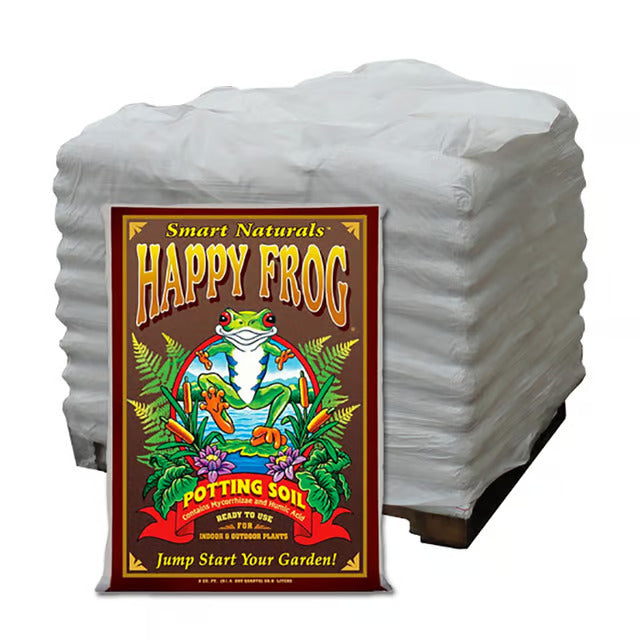 A pallet of white bags of FoxFarm Happy Frog potting soil featuring a frog illustration on a brown background.