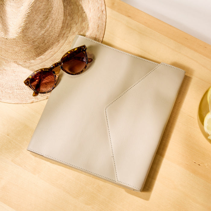 Taupe Vegan Leather - Deluxe Classic Planner Folio displayed on a wooden surface next to tortoiseshell sunglasses and a straw hat, highlighting its sleek, minimalist design.