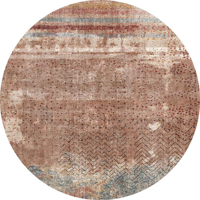 Round rug with a distressed terracotta, blue, and cream abstract pattern featuring horizontal stripes and chevron lines.