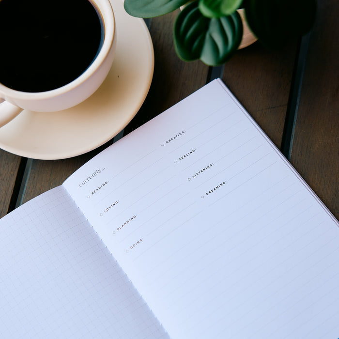 Undated Modern Tones Folio Planner Insert - Monthly Calendar View A5 Layout- 12 Months with a minimalist lined page beside coffee and a plant