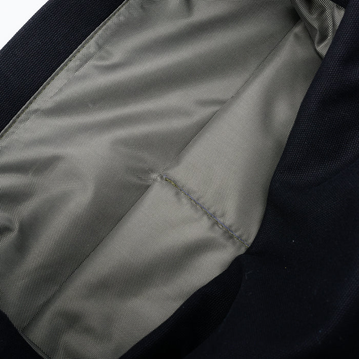 Close-up of grey fabric bag lining with a stitched pocket detail