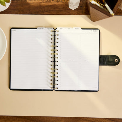 2027 Midnight Micro Dots Customizable Spiral Citrine Planner - Small Professional Layout - 12 Months open with lined notes and daily planning pages on a desk