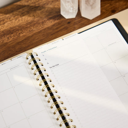 2027 Midnight Plaid Customizable Spiral Citrine Planner - Classic Professional Layout - 12 Months open to a monthly spread with checklist pages and gold spiral binding