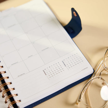 2027 Navy Herringbone Customizable Spiral Citrine Planner - Small Professional Layout - 12 Months open to a monthly calendar layout with spiral binding