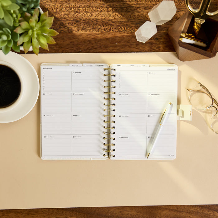 2027 Notes & Plans Customizable Spiral Citrine Planner - Small Professional Layout - 12 Months open on a desk with weekly planning pages and pen