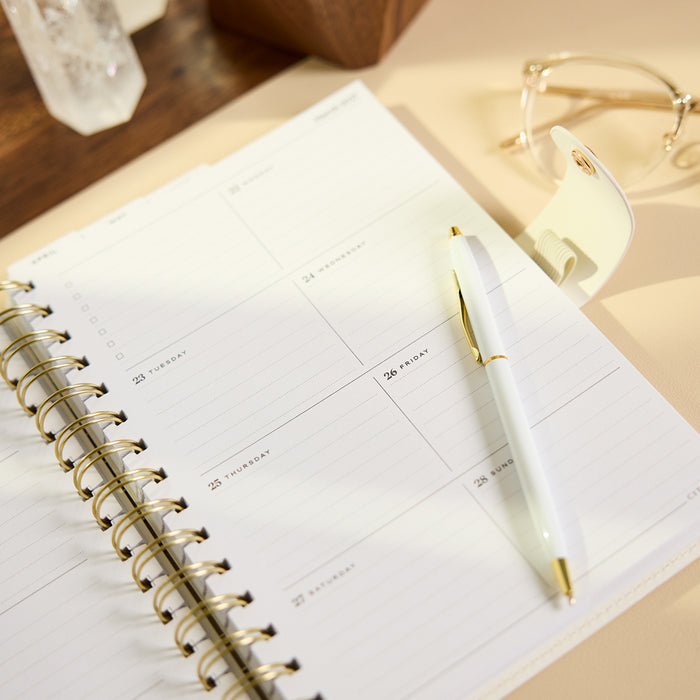 2027 Notes & Plans Customizable Spiral Citrine Planner - Small Professional Layout - 12 Months open to a dated weekly layout with a white pen