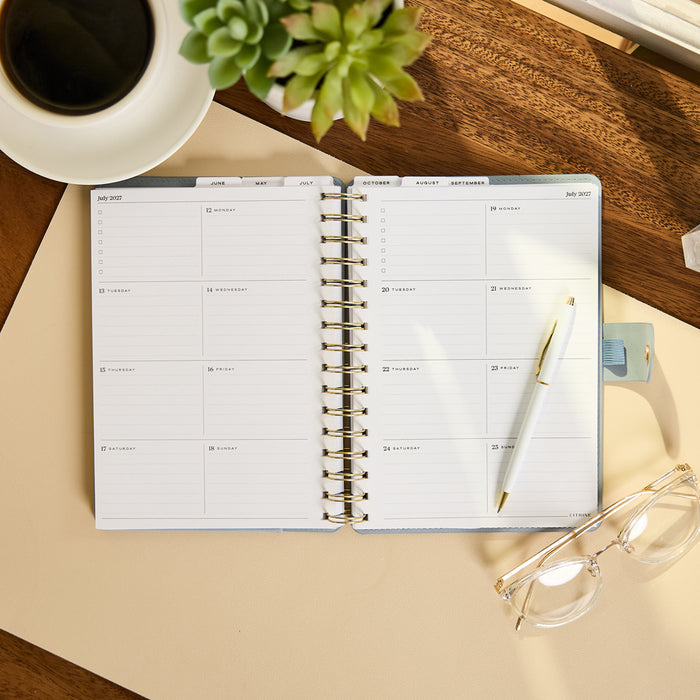 2027 Pastel Horizon Customizable Spiral Citrine Planner - Small Professional Layout - 12 Months open to a weekly spread with pen and organized writing spaces
