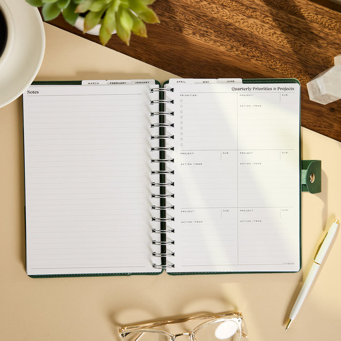 2027 Sage & Scallop Customizable Spiral Citrine Planner - Small Professional Layout - 12 Months open to notes and quarterly priorities and projects pages on a desk