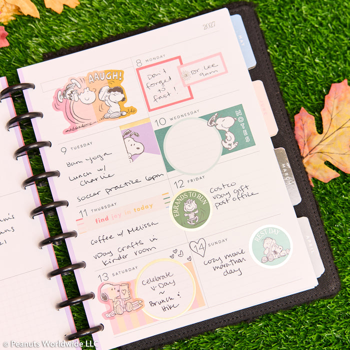 2027 SPECIALTY PEANUTS™ Customizable Planner - Classic Dashboard Layout - 12 Months open to a colorful weekly spread with Snoopy artwork, handwritten notes, and disc binding