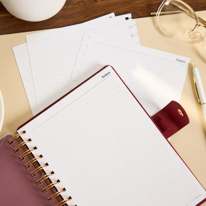Citrine - Small Customizable Spiral Filler Paper with lined notes pages in a spiral notebook on a desk beside loose planner sheets