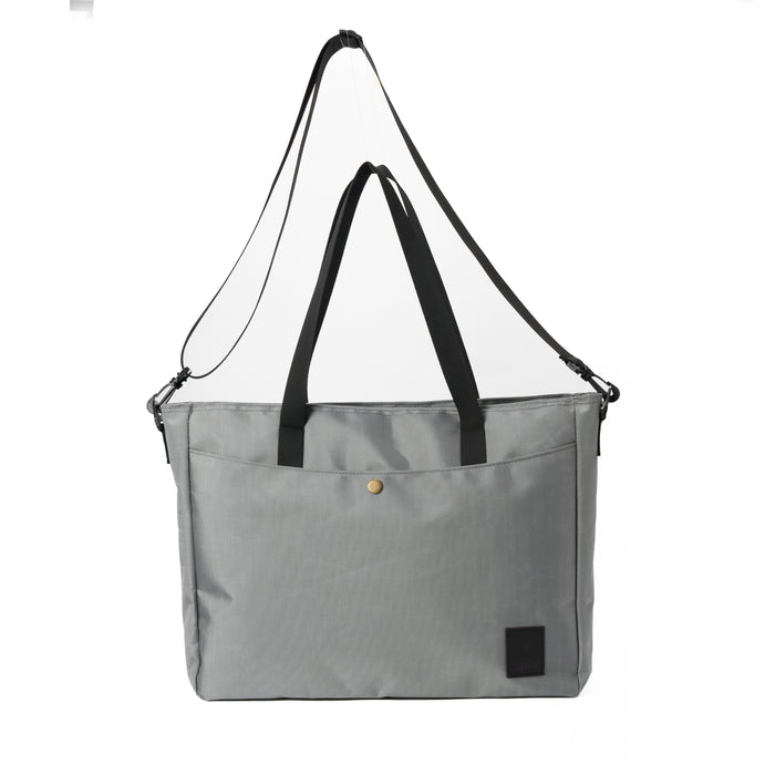 Gray tote bag with black handles and adjustable shoulder strap, front pocket, minimalist design