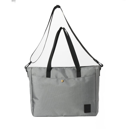Gray tote bag with black handles and adjustable shoulder strap, front pocket, minimalist design