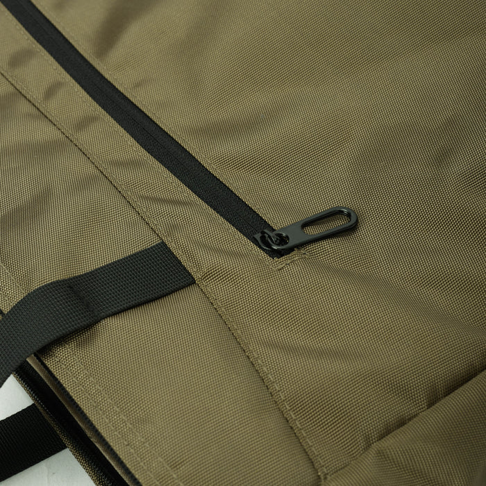 Close-up of khaki travel bag with black zipper and strap detail