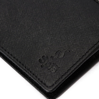 Textured black leather wallet corner with embossed logo detail