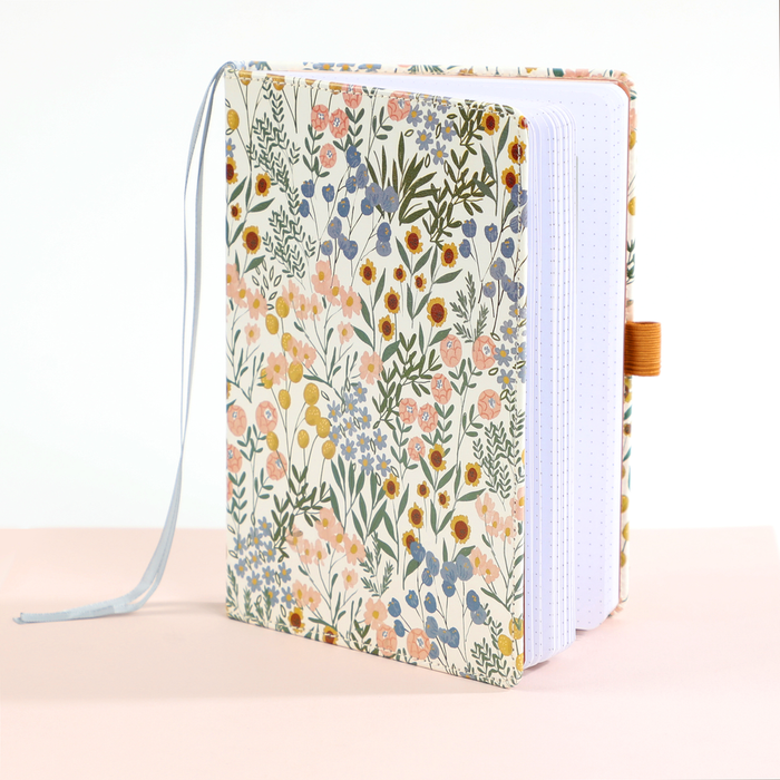 Ditsy Wildflower - Bullet Dot Grid Happy Journal® - 80 Sheets - 160gsm Paper with a floral cover design, featuring a bookmark ribbon and pen loop, standing open on a light surface.