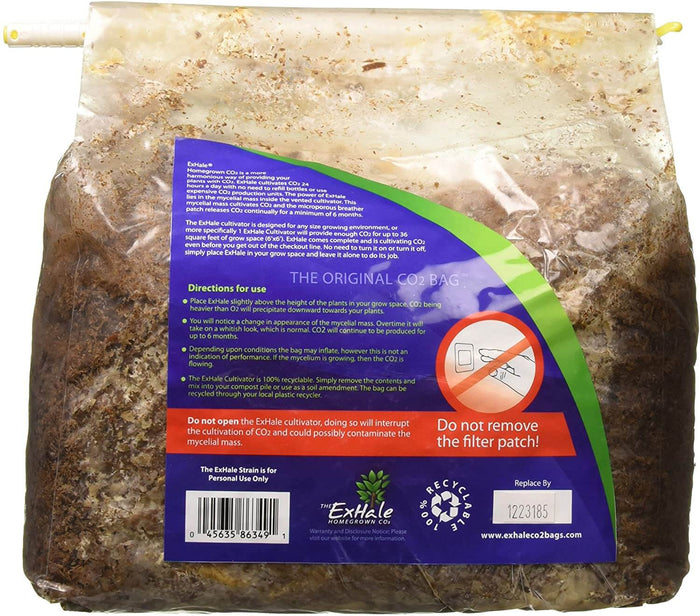 Clear plastic CO2 cultivation bag filled with brown mycelial mass, featuring a large purple and green instructional tag.