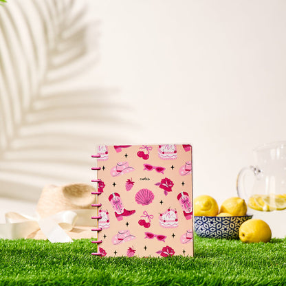 Happy Little Vibes - Dotted Lined Classic Notebook - 60 Sheets with pink summer-themed cover featuring sunglasses, cherries, and seashells, standing on grass with lemon pitcher and straw hat in background.