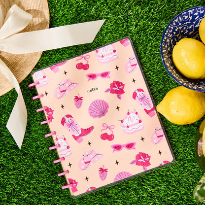 Happy Little Vibes - Dotted Lined Classic Notebook - 60 Sheets with pink disc binding and playful summer-themed cover surrounded by lemons and a wide-brimmed hat on green grass.