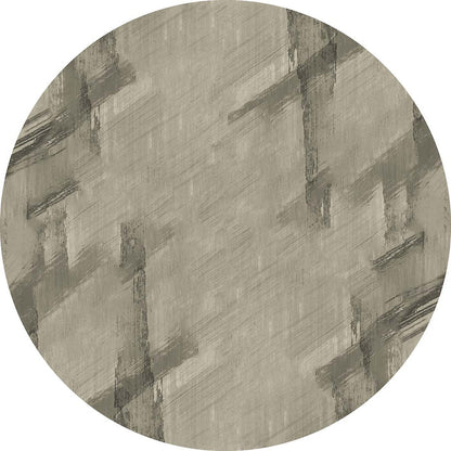 Circular rug in taupe and charcoal with an abstract, distressed brushstroke pattern.