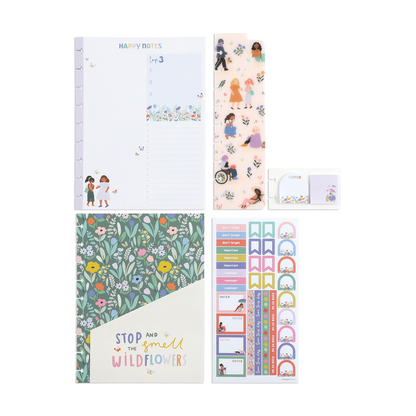 Flat lay of a Squad Goals Love Every Season - Classic Accessory Pack featuring a floral-themed notebook, decorative stickers, a translucent bookmark with illustrated characters, a note keychain, and a guided happy planner-style filler paper with soft pastel colors.