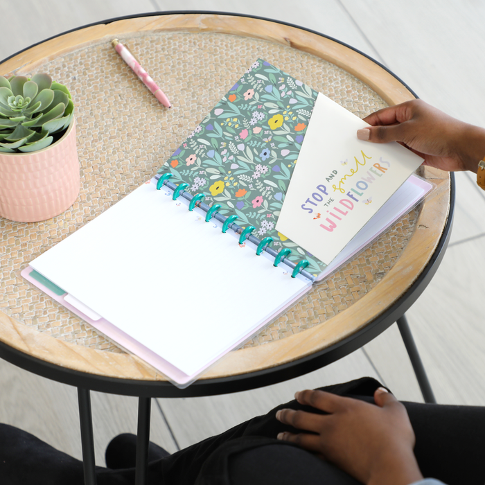 Person flipping through a disc bound planner with colorful floral interior pages and a motivational quote card, featuring the Squad Goals Love Every Season - Classic Accessory Pack.