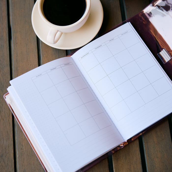 Undated Modern Tones Folio Planner Insert - Monthly Calendar View A5 Layout- 12 Months open to monthly calendar pages beside a coffee cup