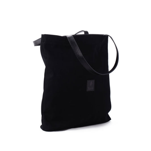 Black canvas shoulder bag with leather strap and small front logo patch on white background
