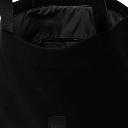 Close-up of black tote bag interior with zippered pocket and sturdy handles