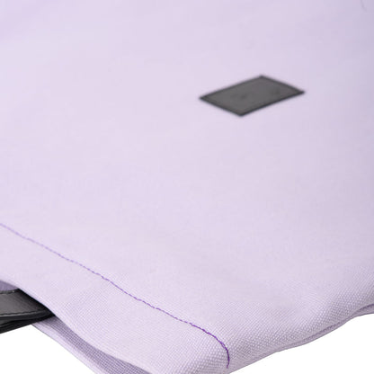 Close-up of a light purple fabric pouch with black tag and visible stitching