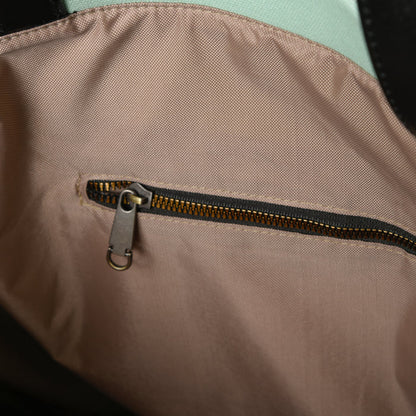 Close-up of a tan fabric bag interior with a small zipper pocket