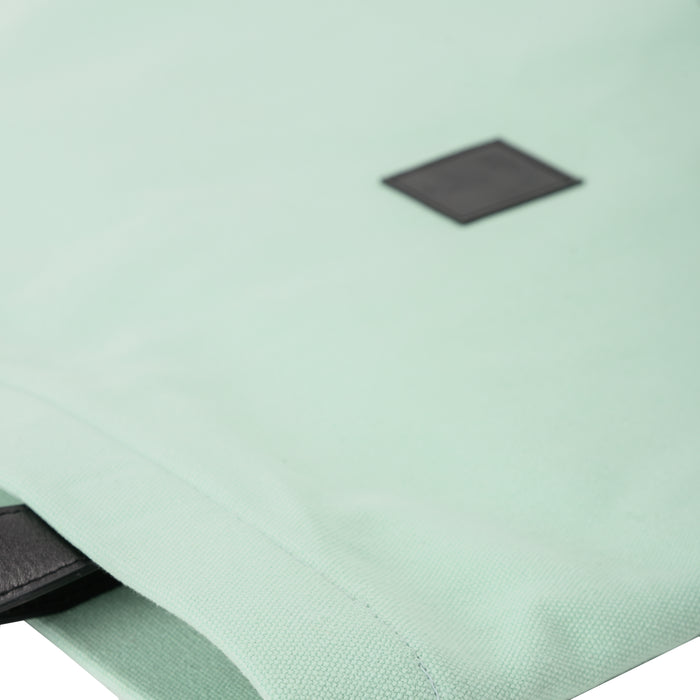 Light mint green fabric shoulder bag with black patch and strap detail