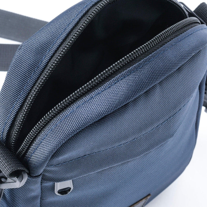 Close-up of blue mini crossbody shoulder bag with zippered main compartment