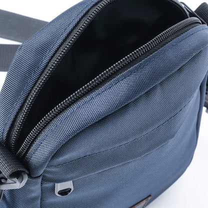 Close-up of blue mini crossbody shoulder bag with zippered main compartment